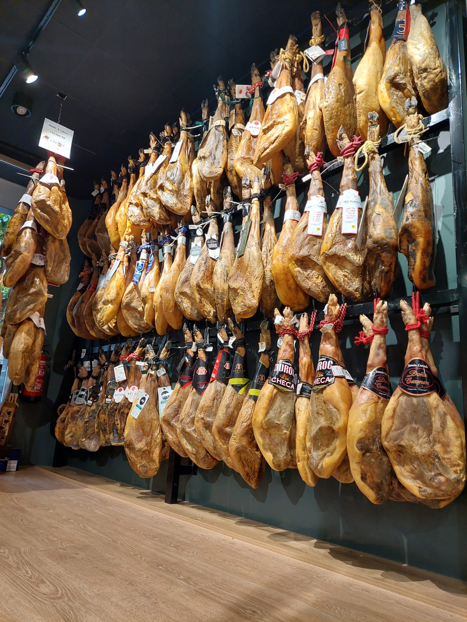 Pared de jamones ibéricos colgados en El Apaño